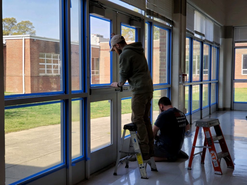 Workers installing window film